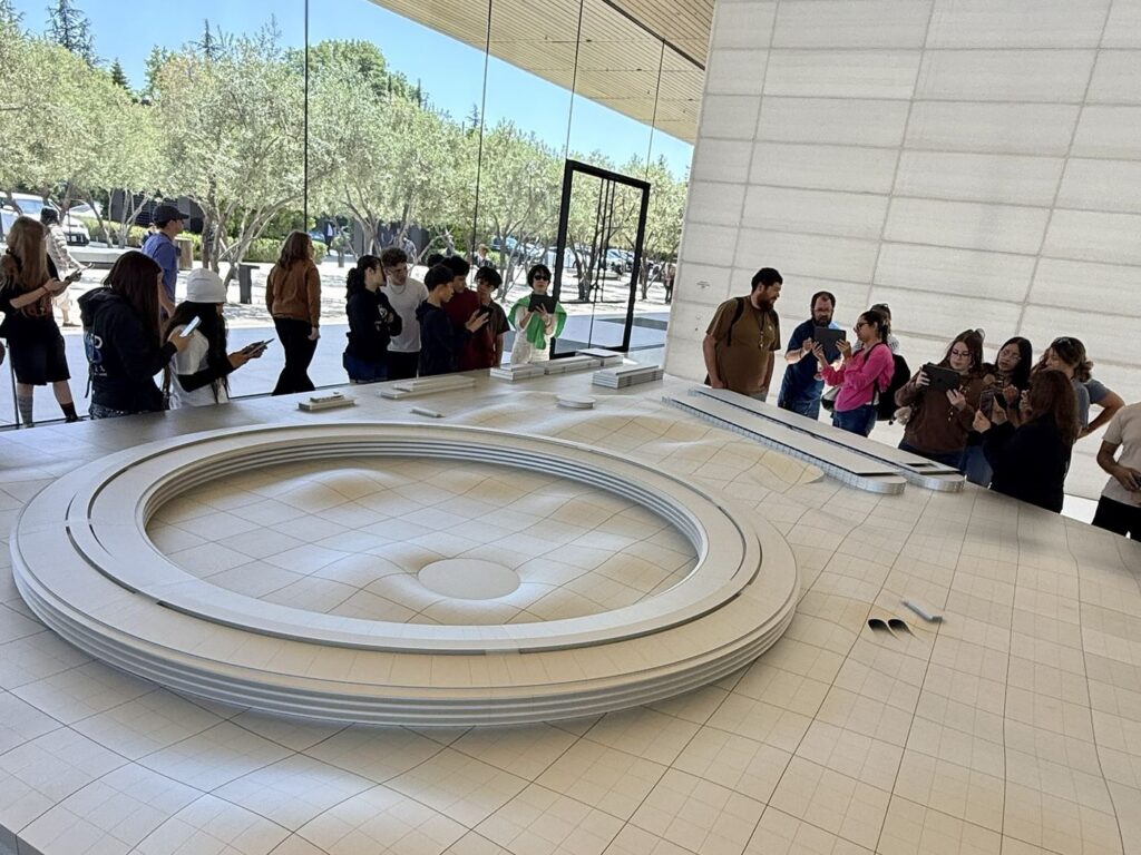 Apple Park Visitor Center'da kampüs maketini inceleyen grup