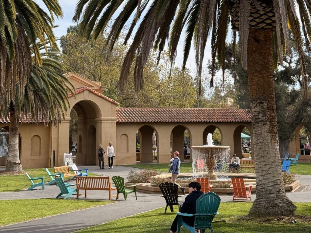 Stanford Üniversitesi kampüsünde çeşme, palmiyeler ve kemerli avlu